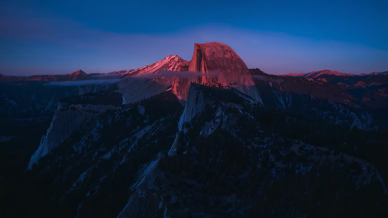 Cupola di granito incandescente che reagisce alla luce alpina del tramonto in una valle montana, banco di nebbia che aggiunge profondità