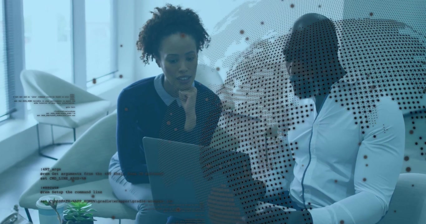 Two coworkers sitting in office lounge reviewing software code, overlaying globe and text snippets