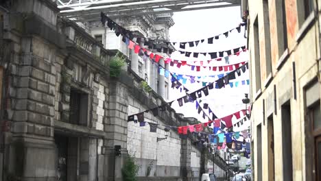 lines of clothes hanging under a bridge in a public street