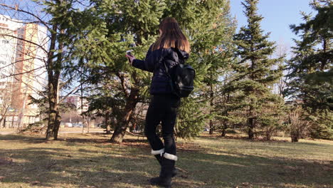 Niña-Tomando-Selfies-Con-Un-Teléfono-Inteligente-Usando-Una-Cámara-Frontal-En-Un-Parque-De-La-Ciudad