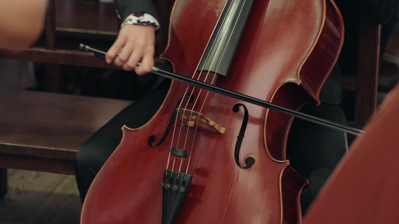 Cellist playing a wooden cello with a bow during a live performance