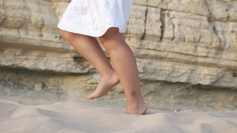 unrecognizable woman running in the summer sunset along the sunny exotic shore in portugal. slow motion, low angle, close-up