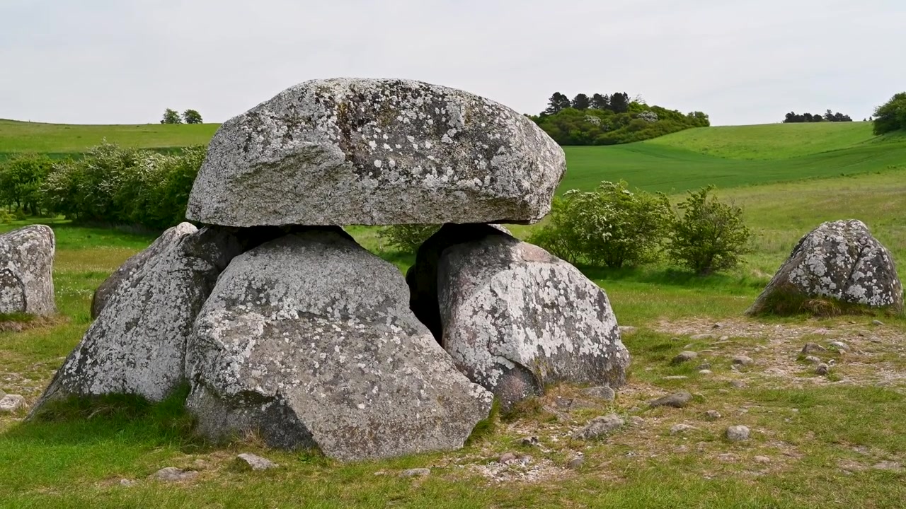 Steinalderruiner på et jorde under skyfull himmel