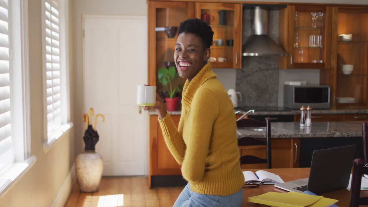 Ritratto di donna afroamericana che beve caffè a casa