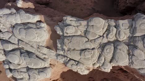 Top-down-ascending-drone-shot-over-a-very-unique-rock-cliff-formation-in-the-Southern-Utah-desert