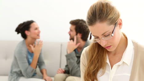 Young-unhappy-couple-sitting-on-sofa-behind-therapist