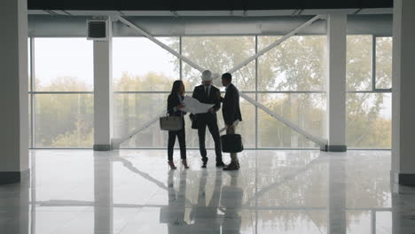 construction team discussing plans in empty building