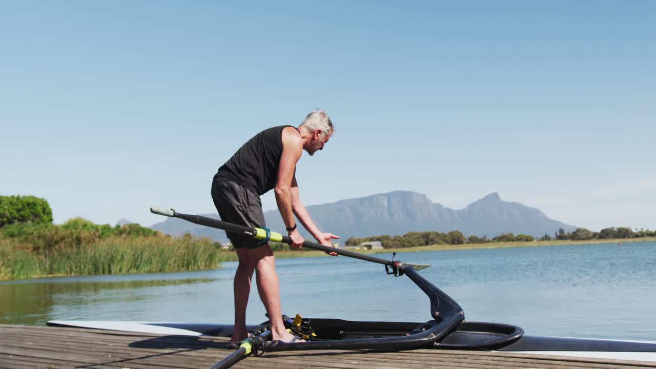 Senior caucasian man preparing rowing boat in a river