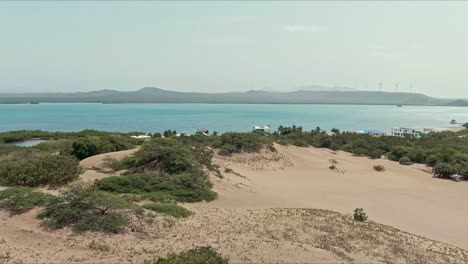 Aerial-view-low-above-dunes-and-vegetation-in-Bani,-Dominican-Republic---pan,-drone-shot