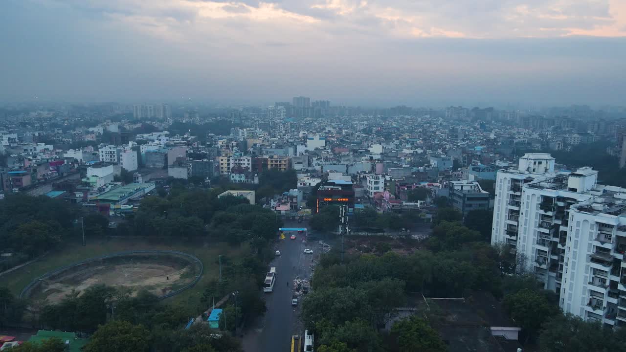 Aerial drone shot displaying the vast expanse of Delhi’s cityscape at blue hour, with empty roads and streetlights still flickering before sunrise.