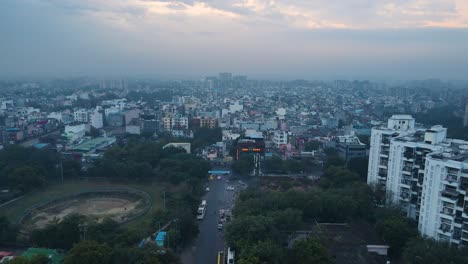 aerial drone shot displaying the vast expanse of delhi’s cityscape at blue hour, with empty roads and streetlights still flickering before sunrise.
