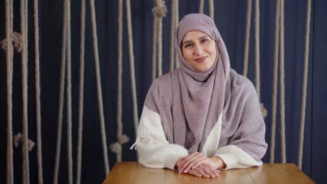 muslim woman in hijab sitting at a table