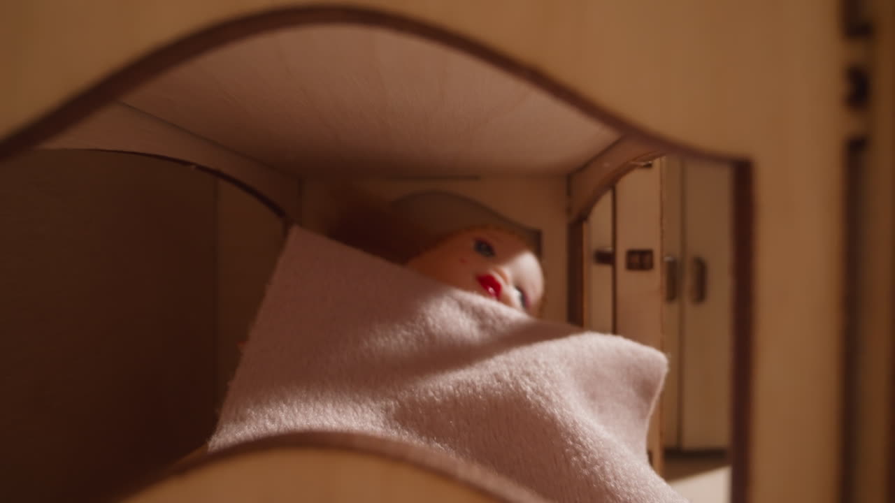 달 ⁇ 한 인형은 태양이 뜨는 동안 인형집에서 장난감 침대에 누워 있습니다.