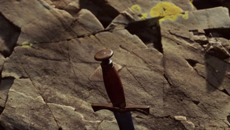 la espada excalibur en la piedra rocosa al atardecer