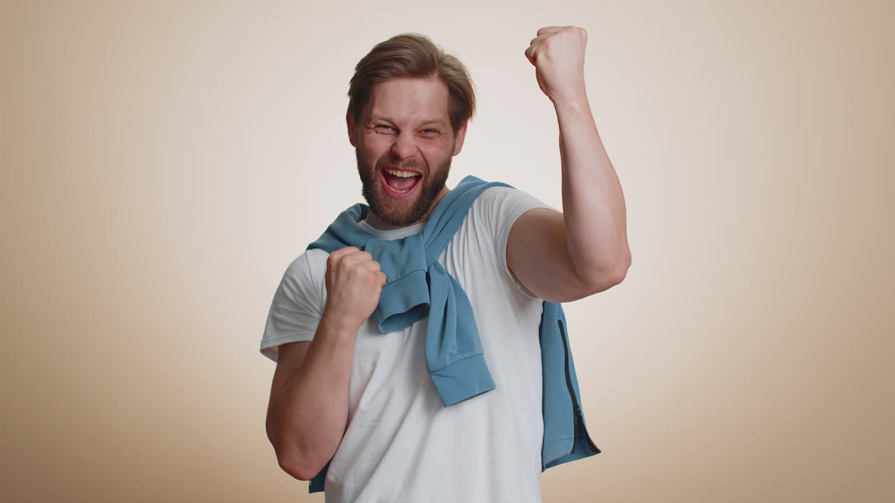 Happy young man celebrating success winning birthday lottery jackpot goal achievemen good news