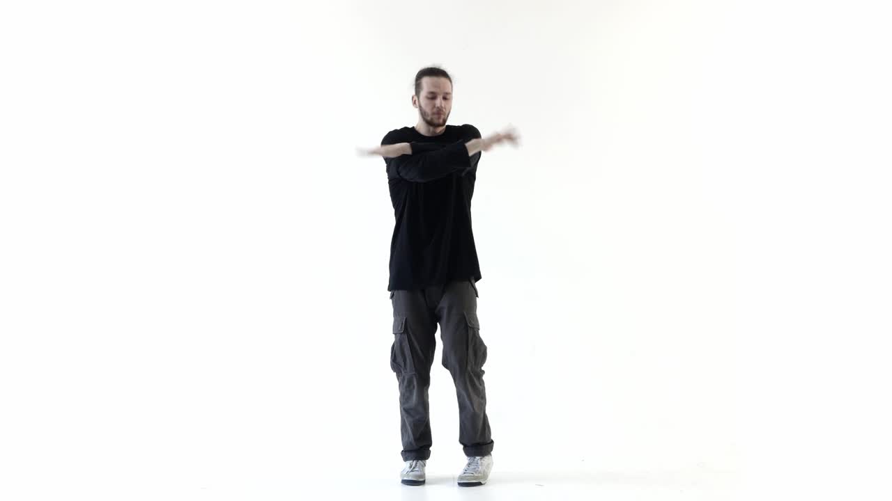 Giovane uomo che esegue energici passi di danza hip hop in uno studio