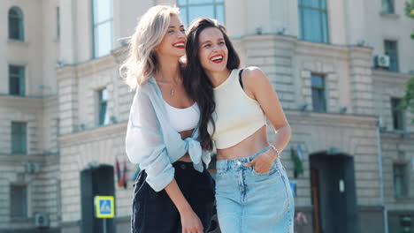 dos mujeres riendo en una calle de la ciudad