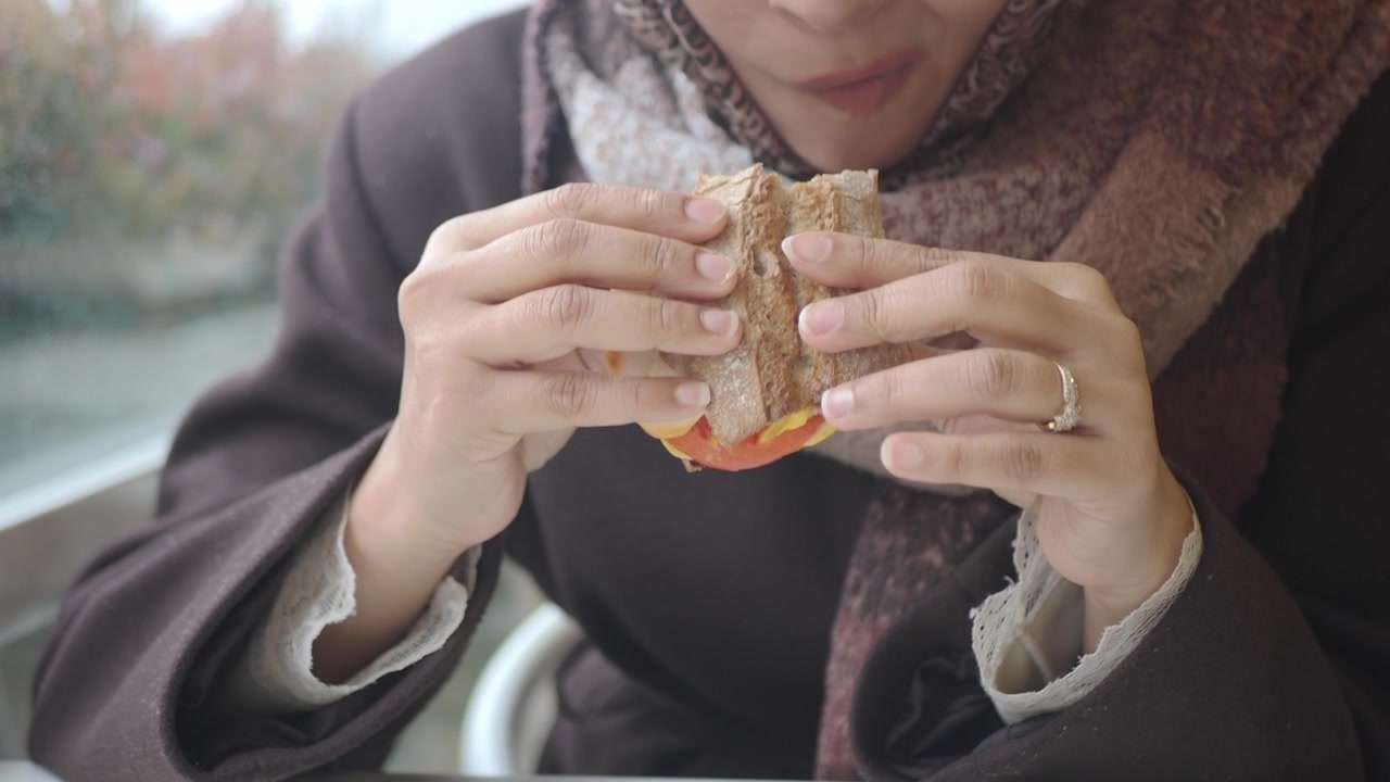 Close-up of Woman Eating a Sandwich Indoors