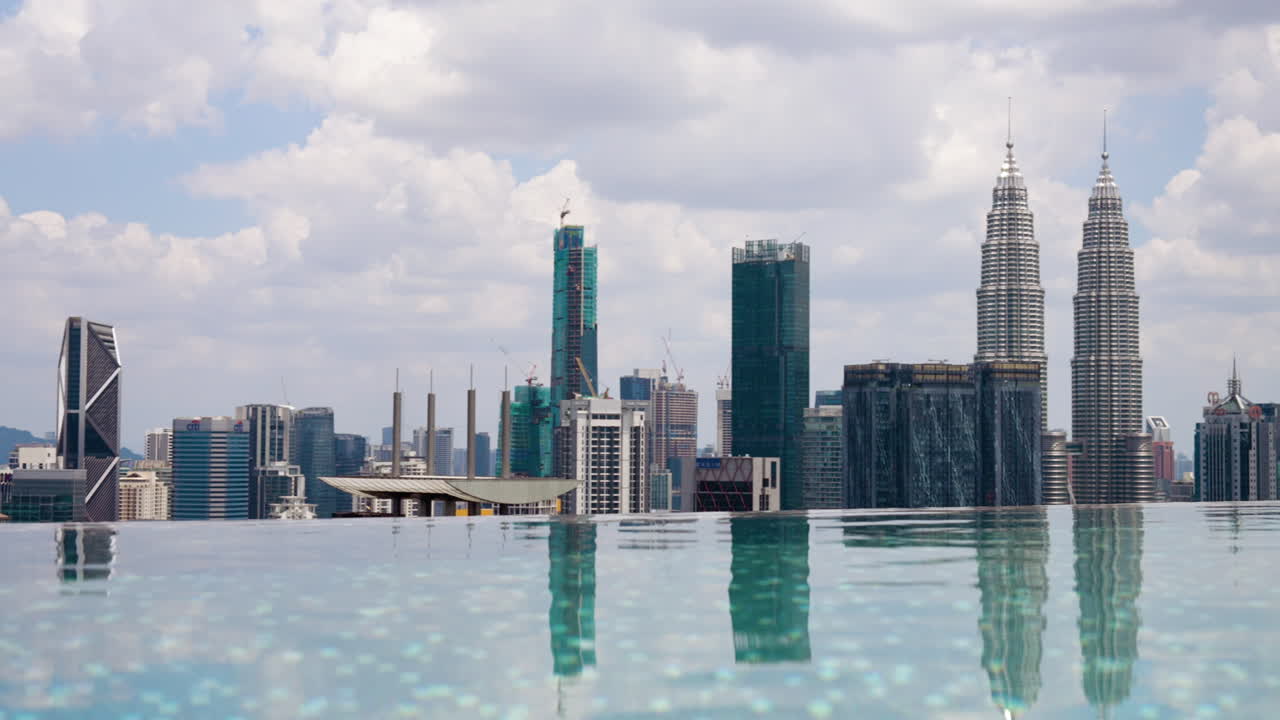 Panorama de los rascacielos de la ciudad de Kuala Lumpur desde la piscina infinita en la azotea de un hotel en un día soleado.