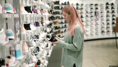 Shopping-in-shoes-store,-woman-is-choosing-winter-boots