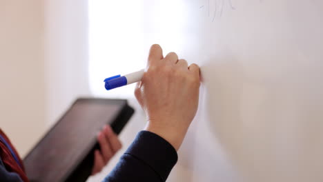 whiteboard, tablet and teacher hands writing