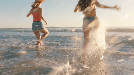 amigas chicas corriendo en la playa hacia el mar divirtiéndose salpicando en el agua chicas adolescentes disfrutando de un cálido día de verano de vacaciones