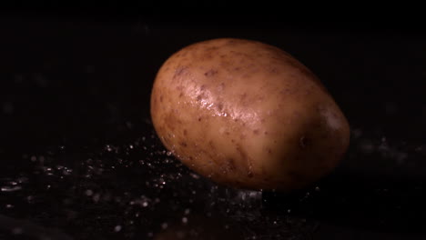 potato falling on wet black surface