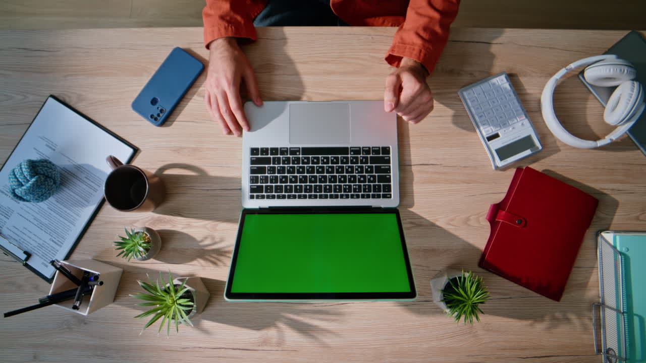 Online manager working mockup laptop at remote workspace top view. Man hands