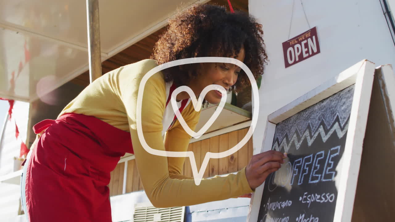 Writing on chalkboard, person in red apron with open sign in background