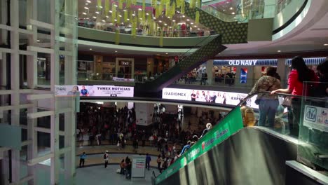 busy shopping mall with crowds moving on multiple levels under bright lights in a bustling environment