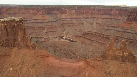 Drohnenaufnahme-Malerischer-Roter-Sandsteinformationen-Und-Eines-Tals-In-Der-Wüstenlandschaft-Von-Utah,-USA