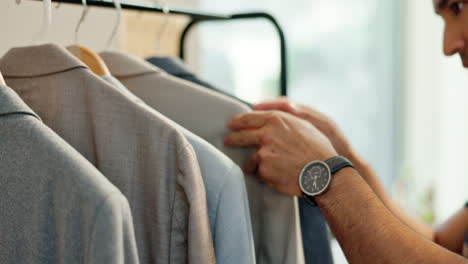 man, suit and clothes rack in boutique