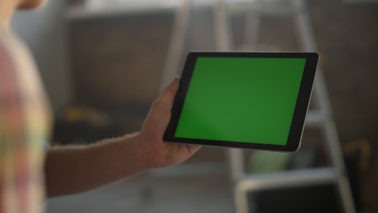 человек с планшетом в руке в помещении. неизвестный парень использует современный гаджет для дизайна.