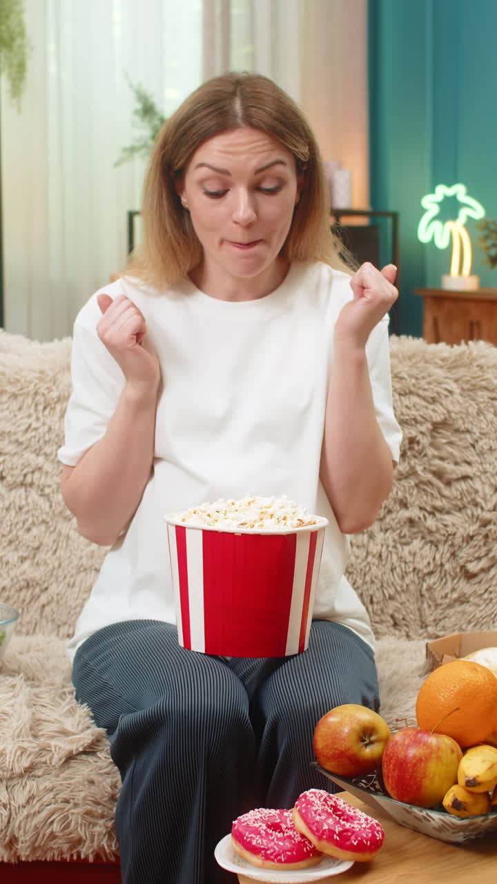 Una donna incinta desidera ardentemente pizza, cioccolato, frutta, patatine e popcorn; vuole mangiare di tutto per saziare la fame durante la gravidanza.