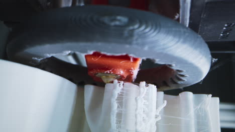 close-up of a 3d printer creating a white plastic object