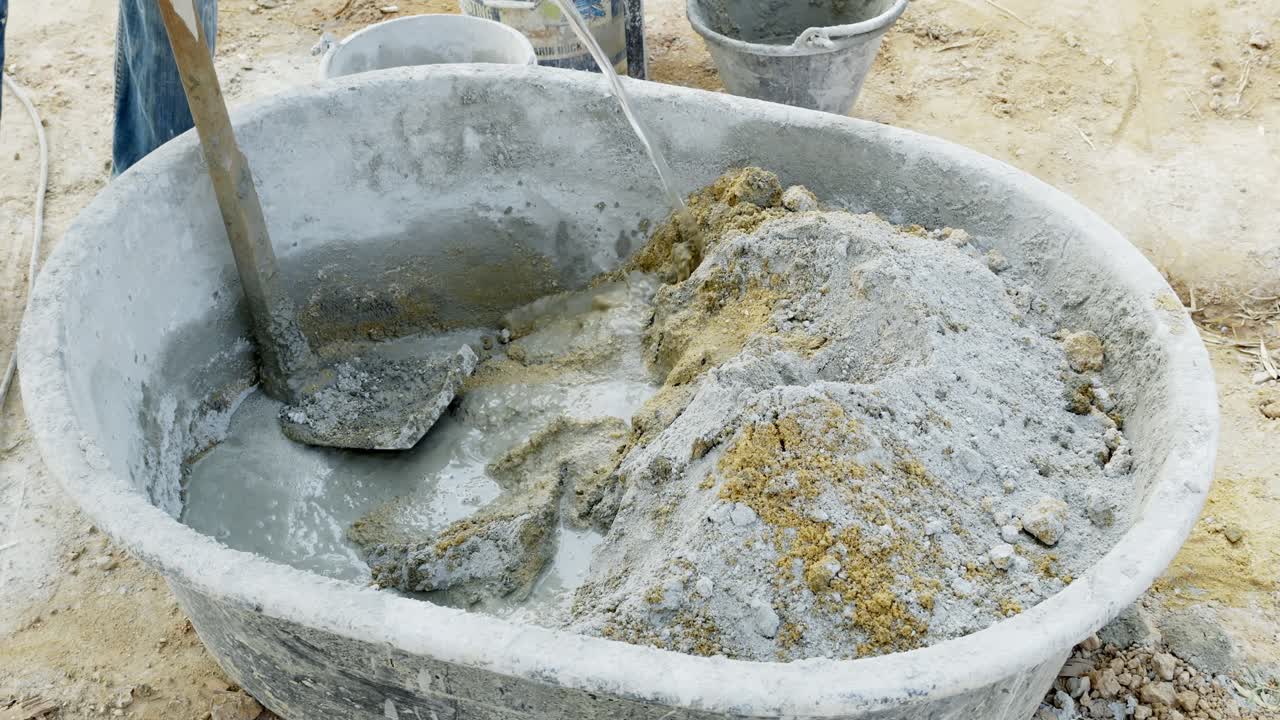 Una mirada detallada a la preparación de una mezcla de cemento para construcción, mostrando el proceso al aire libre
