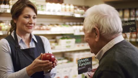 a warm encounter: friendly grocery store interaction between a shopkeeper and an elderly customer discussing fresh produce items