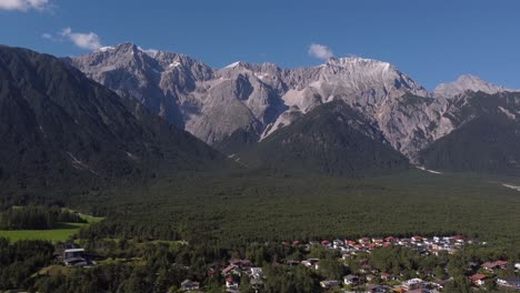 High-altitude-footage-of-drone-facing-a-mountain-in-the-alps-on-a-sunny-day-in-Europe-descending-down