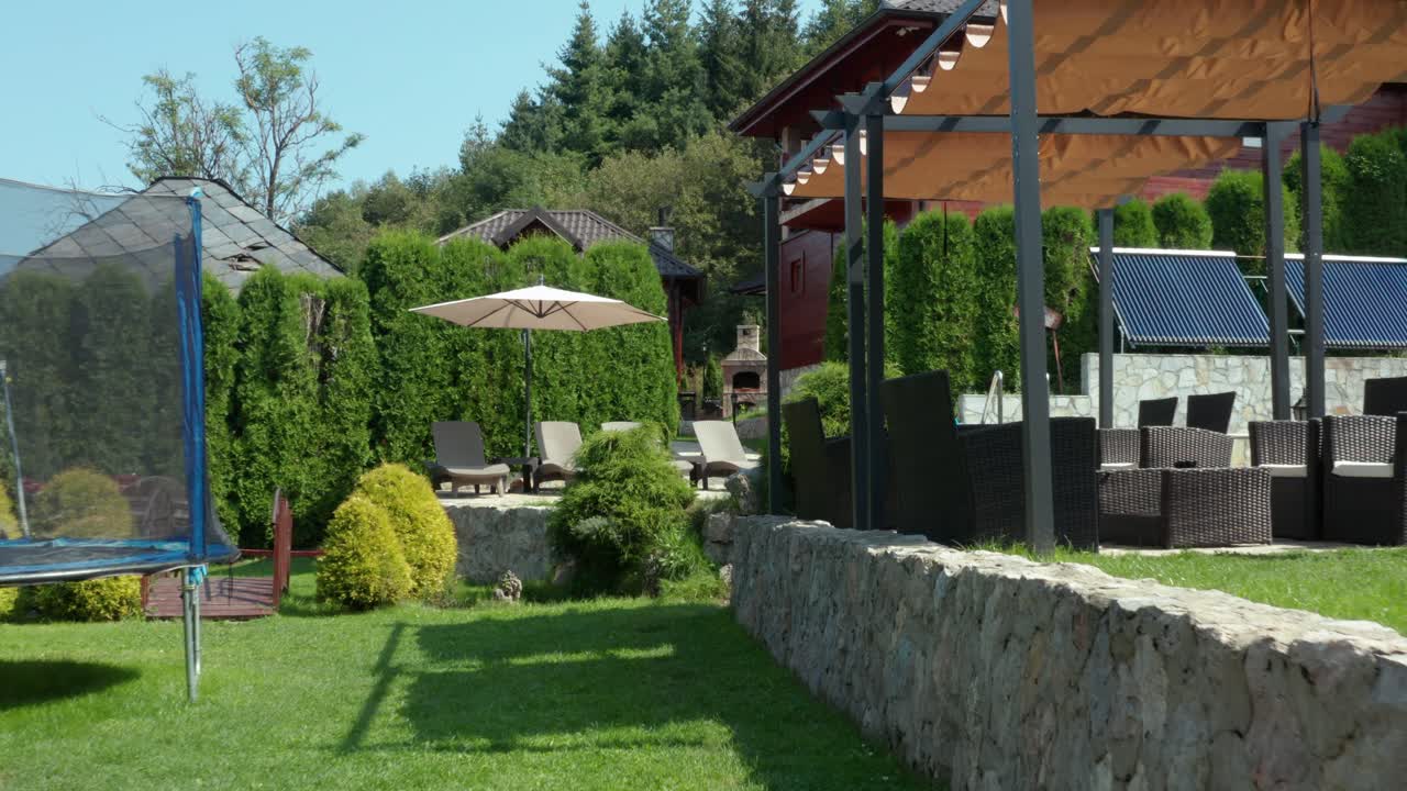 Beautiful mountainside wooden villa house in summer, view through garden