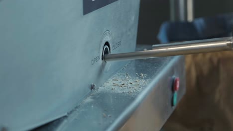 a young brewer controls the grinding of malt seeds in a mill at a modern brewery