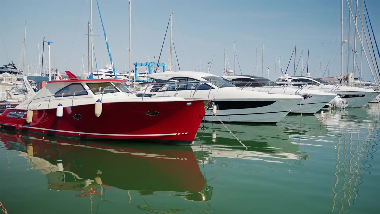 Yacht di lusso e motoscafi ormeggiati al porto turistico di Cannes sotto un cielo azzurro e sereno.