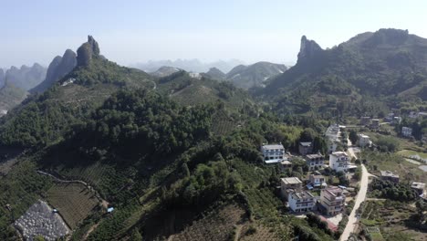 toma aérea ascendente de una ciudad aislada rodeada de montañas en yangshuo, china