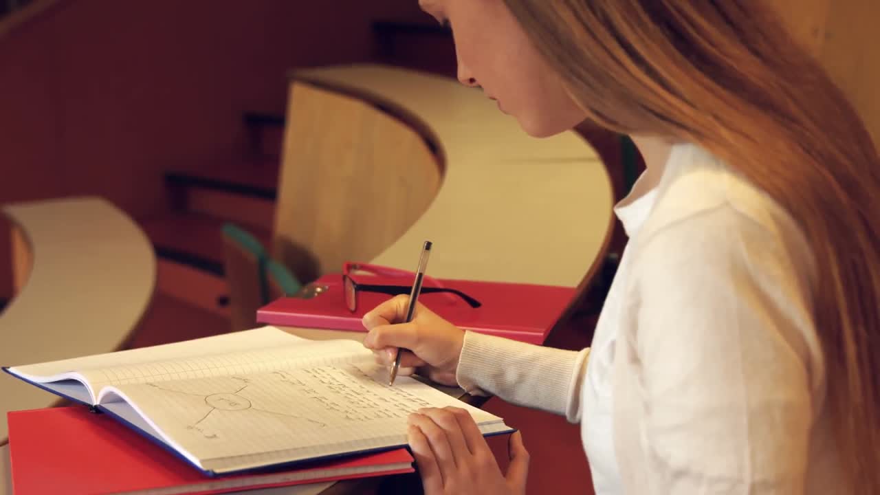 estudiante tomando notas en la clase