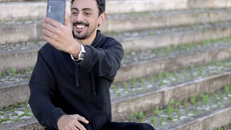 hombre sonriente teniendo chat de video en la calle