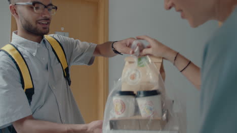 woman receiving food order from delivery guy