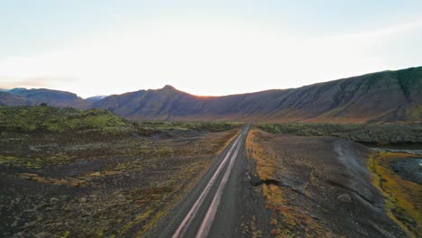 white suv driving on countryside road in amazing colorful volcanic iceland landscape during sunset