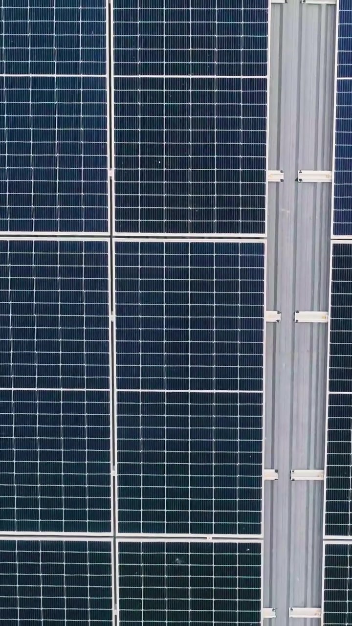 Una vista aérea de paneles solares en un tejado, mostrando energía renovable y tecnología sostenible.