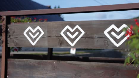 Ornamental-traditional-Slovakian-symbols-are-painted-on-a-wooden-rural-village-house-in-Čičmany,-Slovakia,-worlds-cultural-heritage,-a-famous-landmark-in-central-Europe,-plants-revealing-wooden-fence