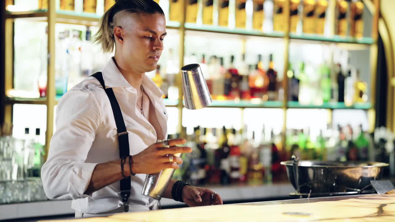 Barman professionista prepara un cocktail con uno shaker in un bar moderno