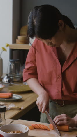woman chopping carrots for a meal